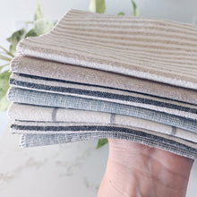 Load image into Gallery viewer, hand holding stack of linen drying mats, Mugs drip drying on a handmade in the USA mist blue homespun linen dish drying mat, washable dish drying mat, oversized paperless towel, farmhouse kitchen, simple minimalist kitchen, natural fiber drying mat, beautiful simple kitchen accessories, woman owned small shop, small business, made in south dakota