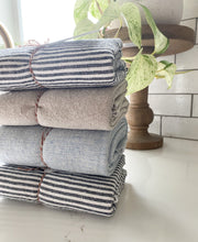 Load image into Gallery viewer, folded stack of linen drying mats in white kitchen with marble queen pothos house plant in background, white kitchen, Mugs drip drying on a handmade in the USA mist blue homespun linen dish drying mat, washable dish drying mat, oversized paperless towel, farmhouse kitchen, simple minimalist kitchen, natural fiber drying mat, beautiful simple kitchen accessories, woman owned small shop, small business, made in south dakota