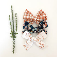 Load image into Gallery viewer, Rust Fall Floral Bows, Boho Fabric Bow Clips or Headbands, Classic Navy Pinwheel Set, Terracotta Gingham Check Bow, Copper Wildflower Bow, handmade fabric bows, boho style baby hair bows, burnt orange gingham check bow, navy floral hair bow, burnt orange floral vintage style hair bow, family pictures hair bow, school pictures hair bow, baby hair clips, handmade in the USA, made in the USA, stocking stuffer for girl, baby shower gift for girl, baby shower prize for girl