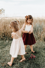 Load image into Gallery viewer, two girls playing in vintage style outdoor family photo wearing handmade slow fashion dresses and earth tone lace hair bow
